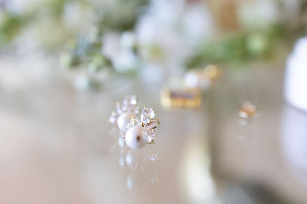 A delicate floral branch with small white cherry or apple blossoms against a soft blurred background.