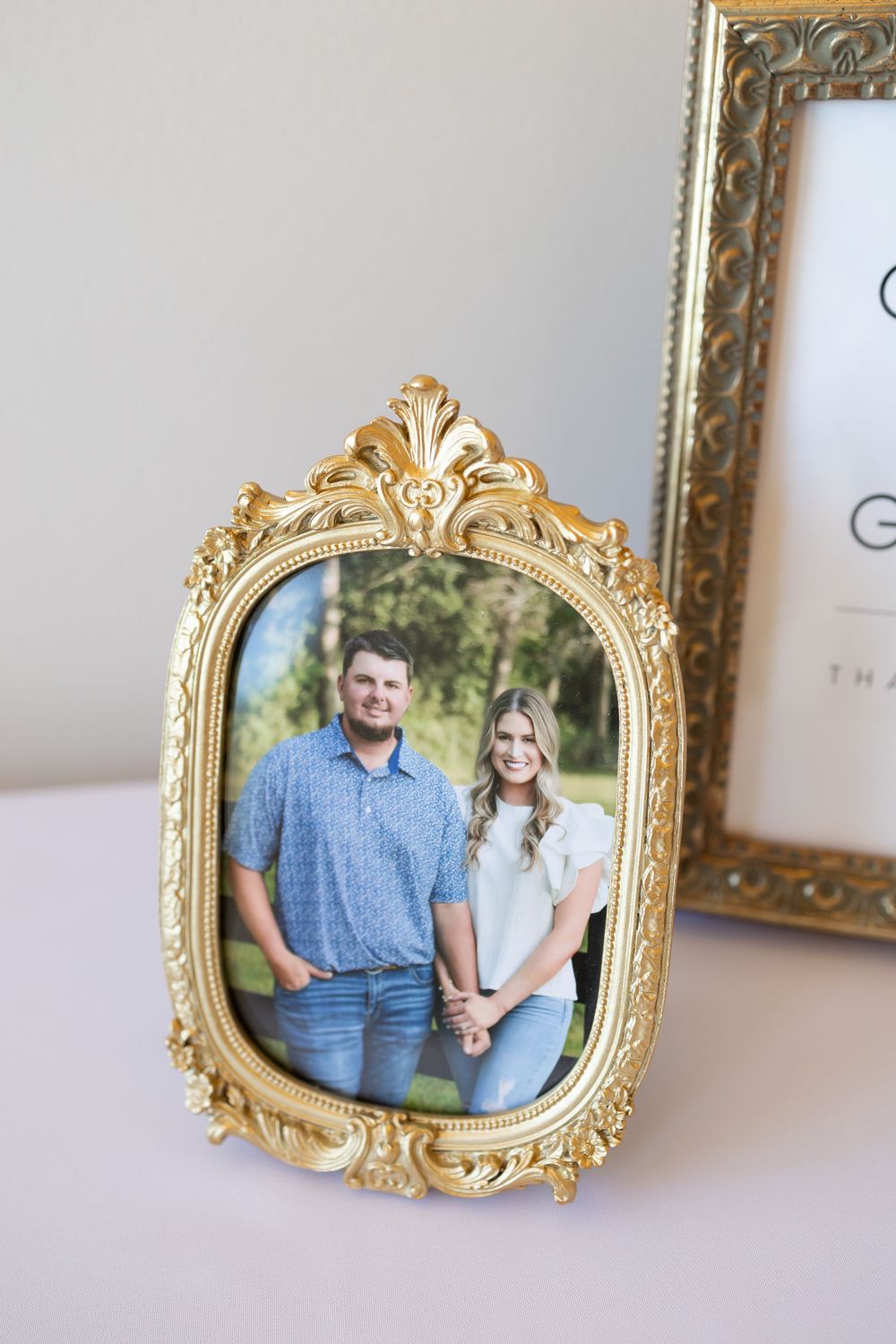 Vintage ornate gold frames displaying portrait photographs arranged in a row on a light surface.