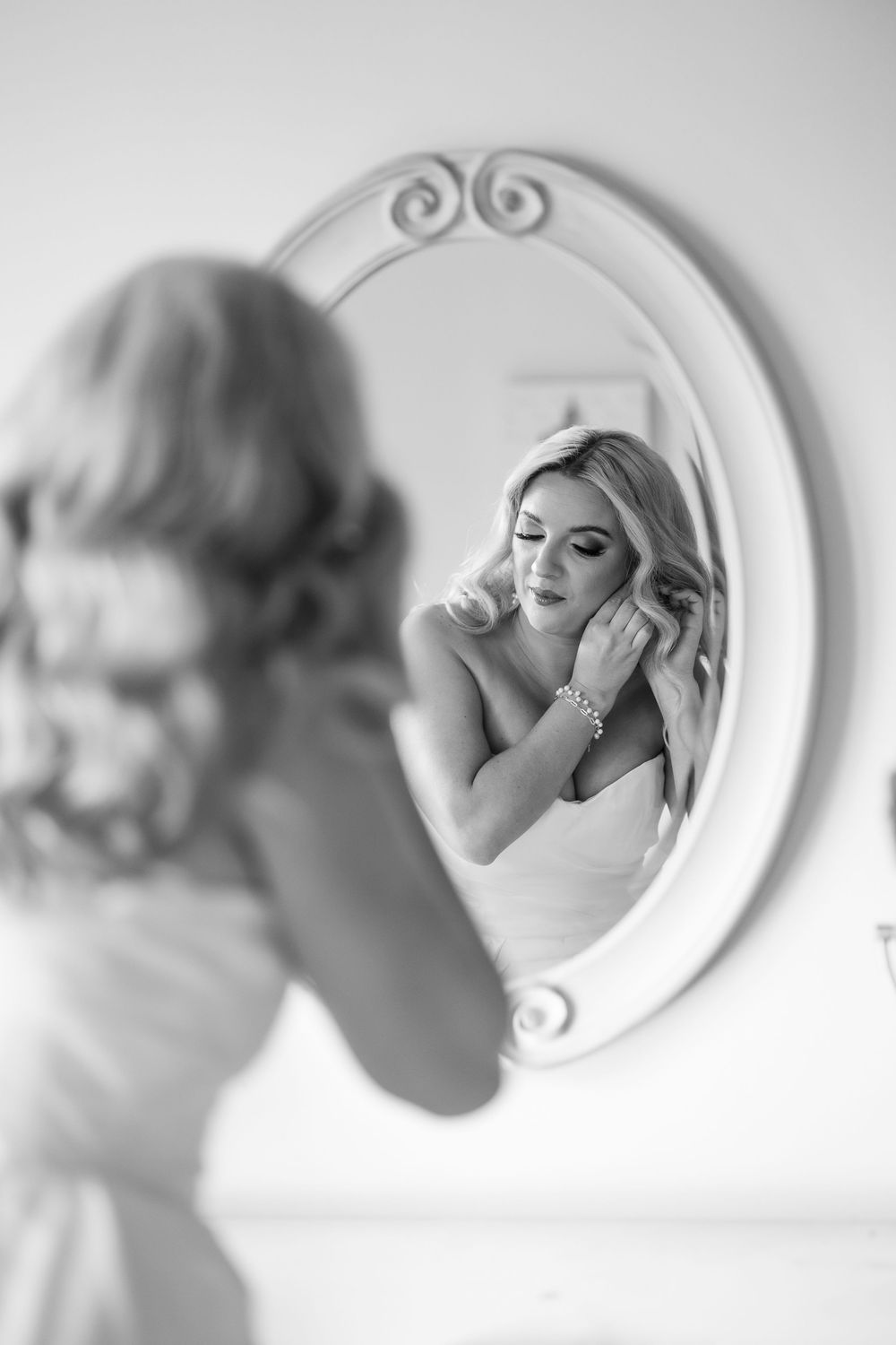 A sequence of artistic black and white mirror reflections showing someone applying lipstick in soft focus.