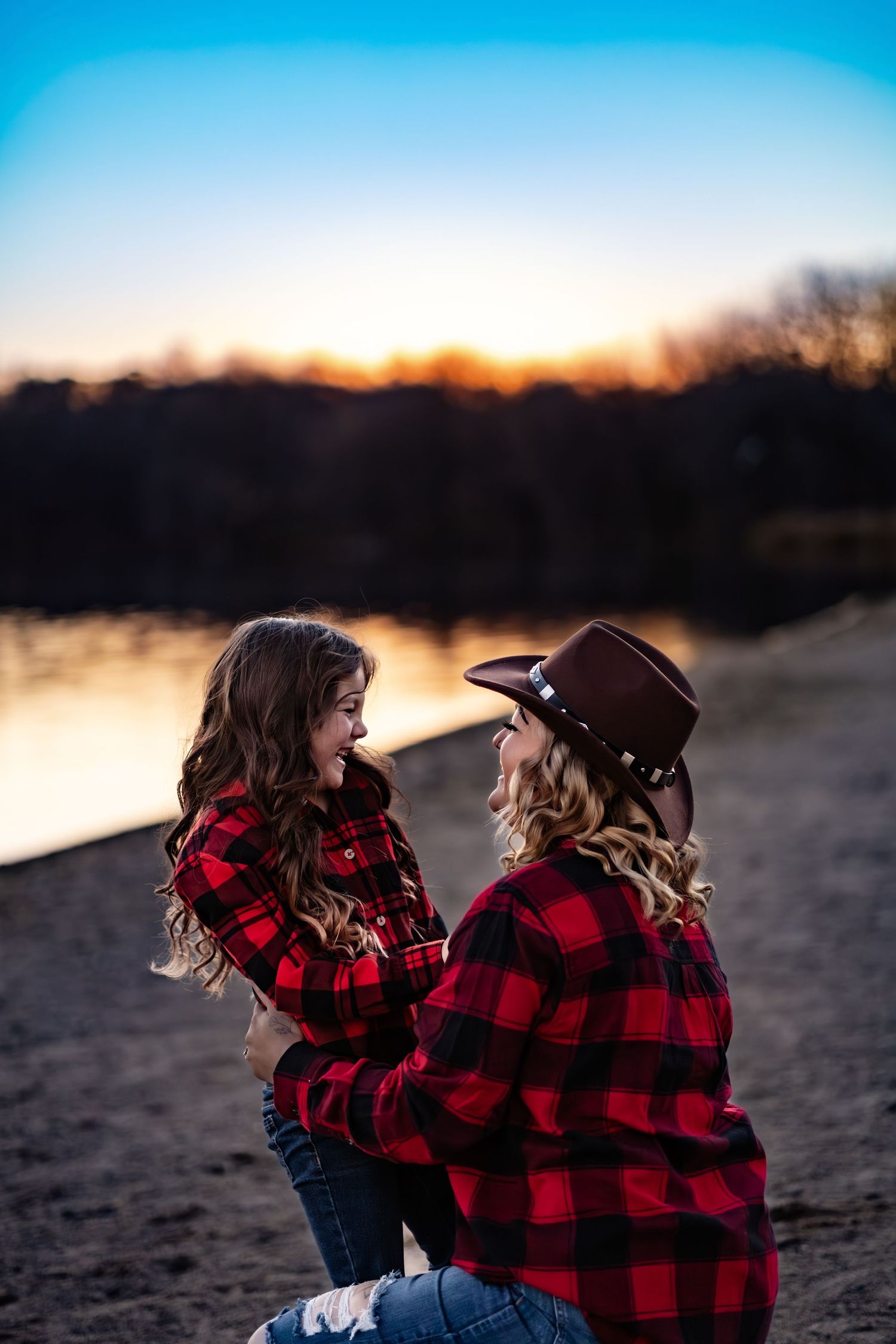 A mother tickling her daughter outside by the beach in Minnesota