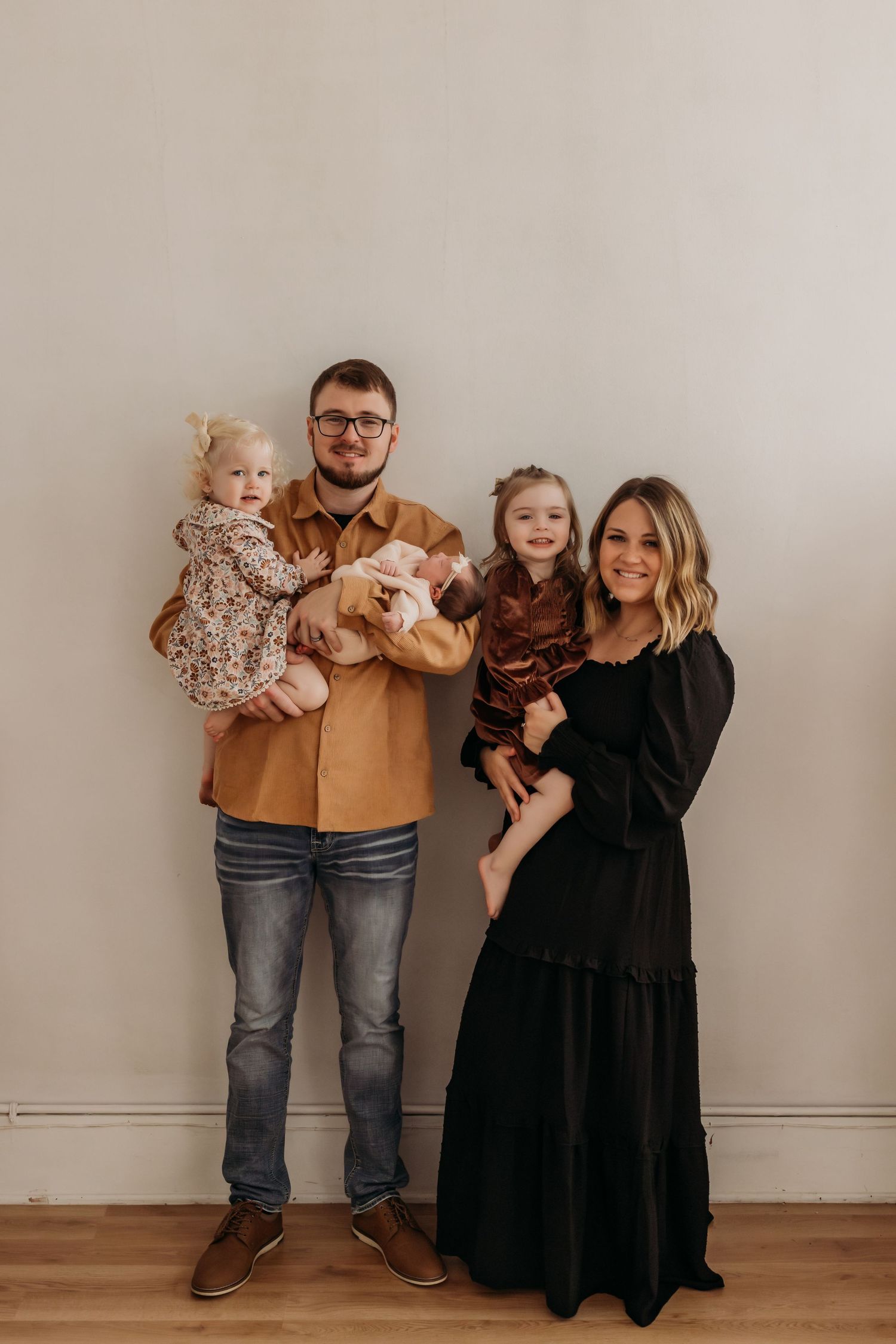 Family portrait series in coordinating neutral outfits against minimal white background.