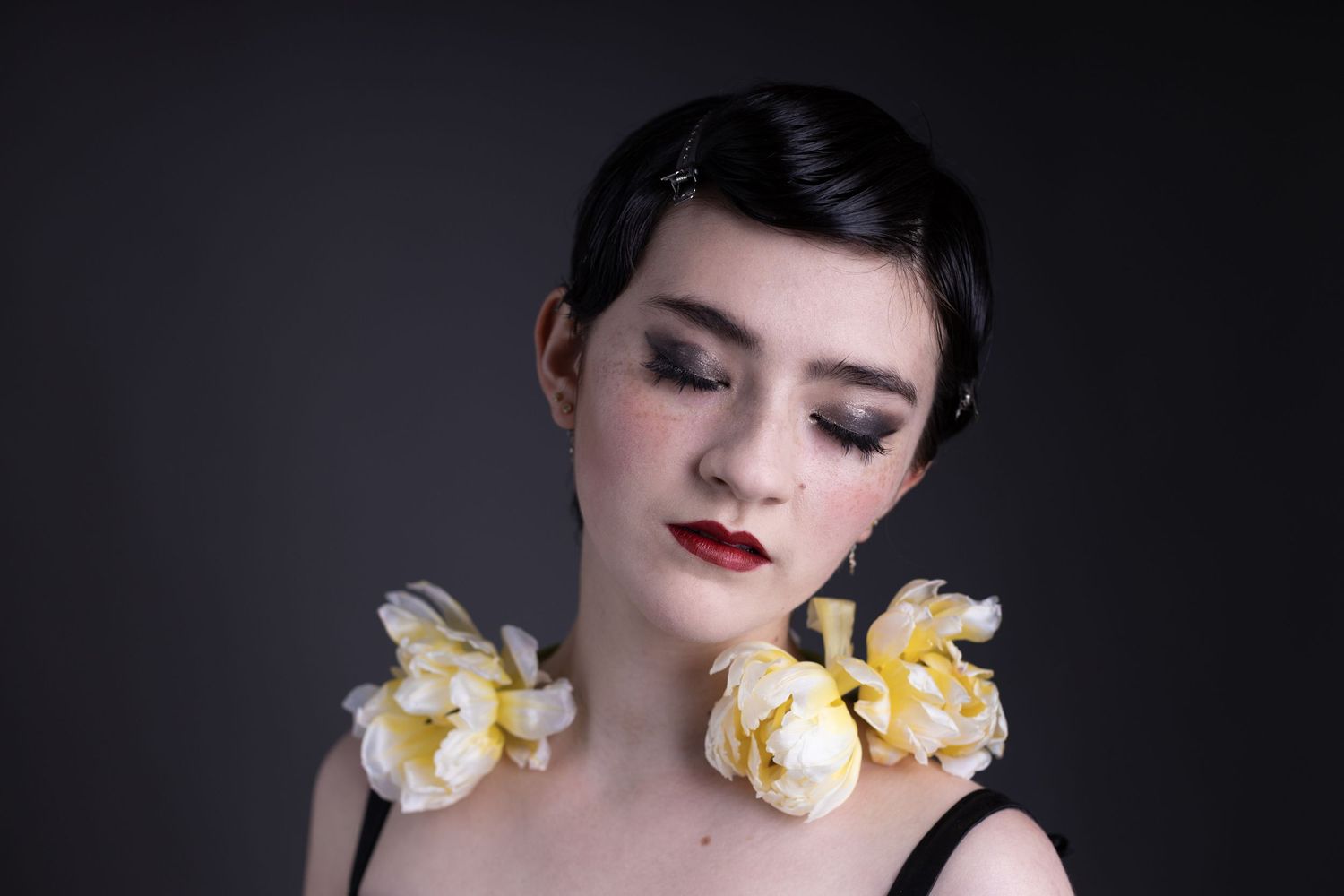 Young model with flower tulips around neck and goth make up - editorial and fashion photography