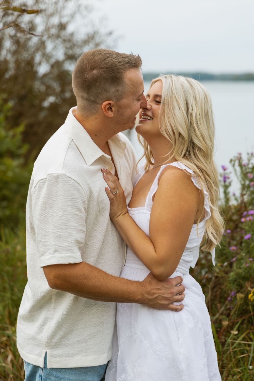 couple kissing on shore of beach during engagement photo session