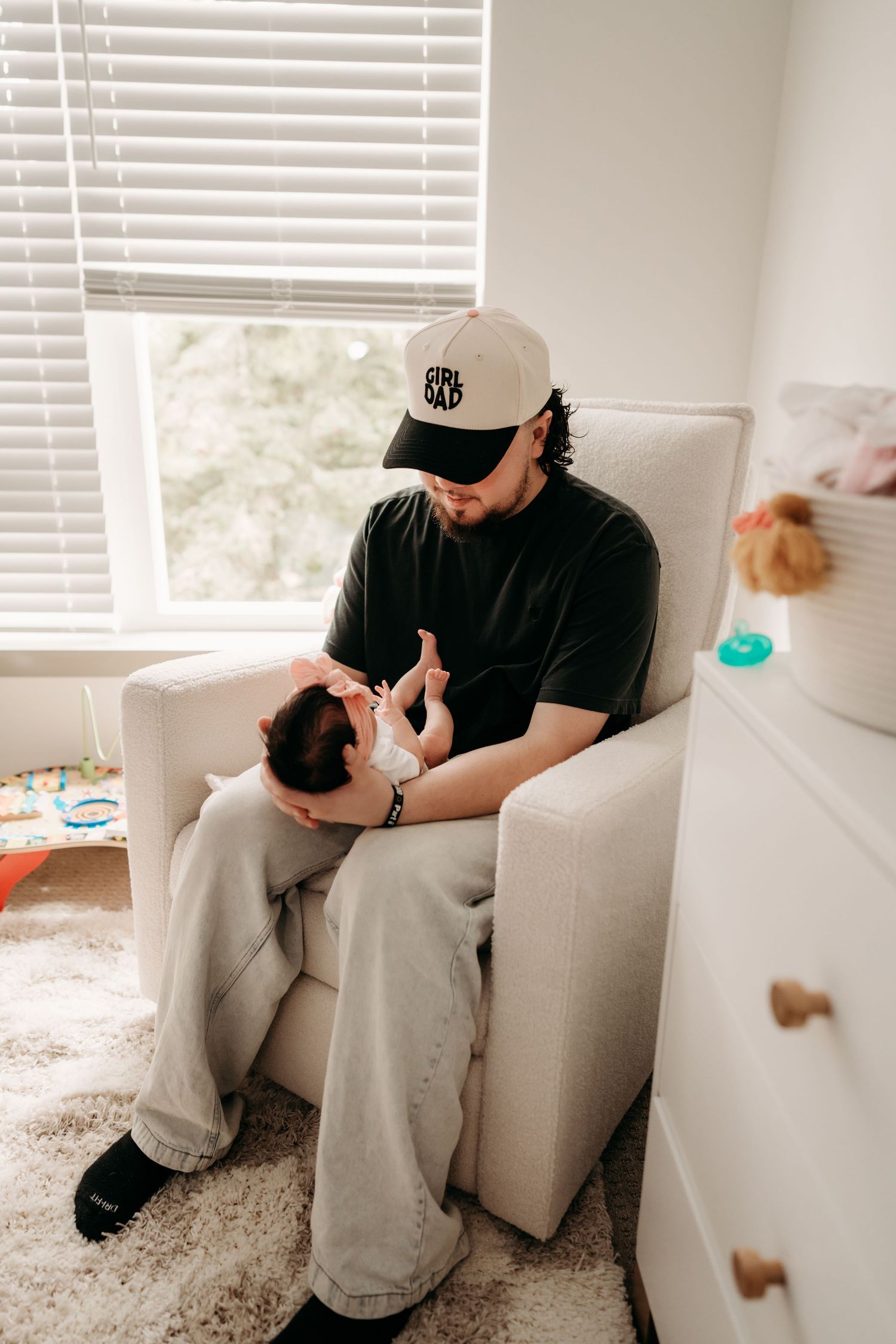 Mom and dad sit on the nursery floor holding their newborn baby and admiring him during in home newborn photo session in Bonney Lake.