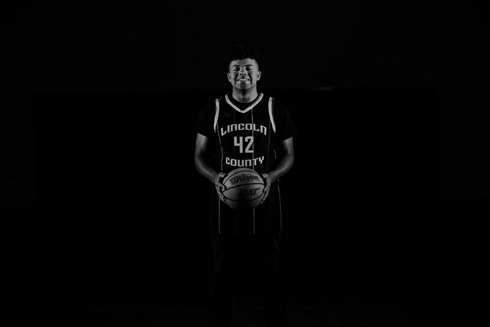 Basketball player in black Brooklyn Nets jersey dribbles the ball on court during game action.