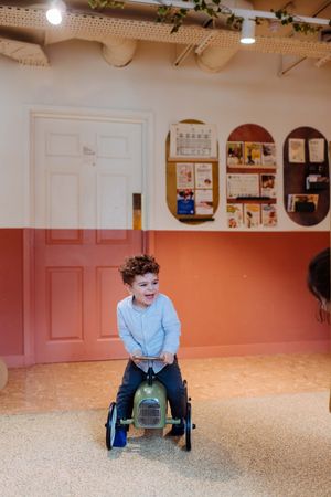 Little boy on his bobby car during a family session in London. London family photographer.