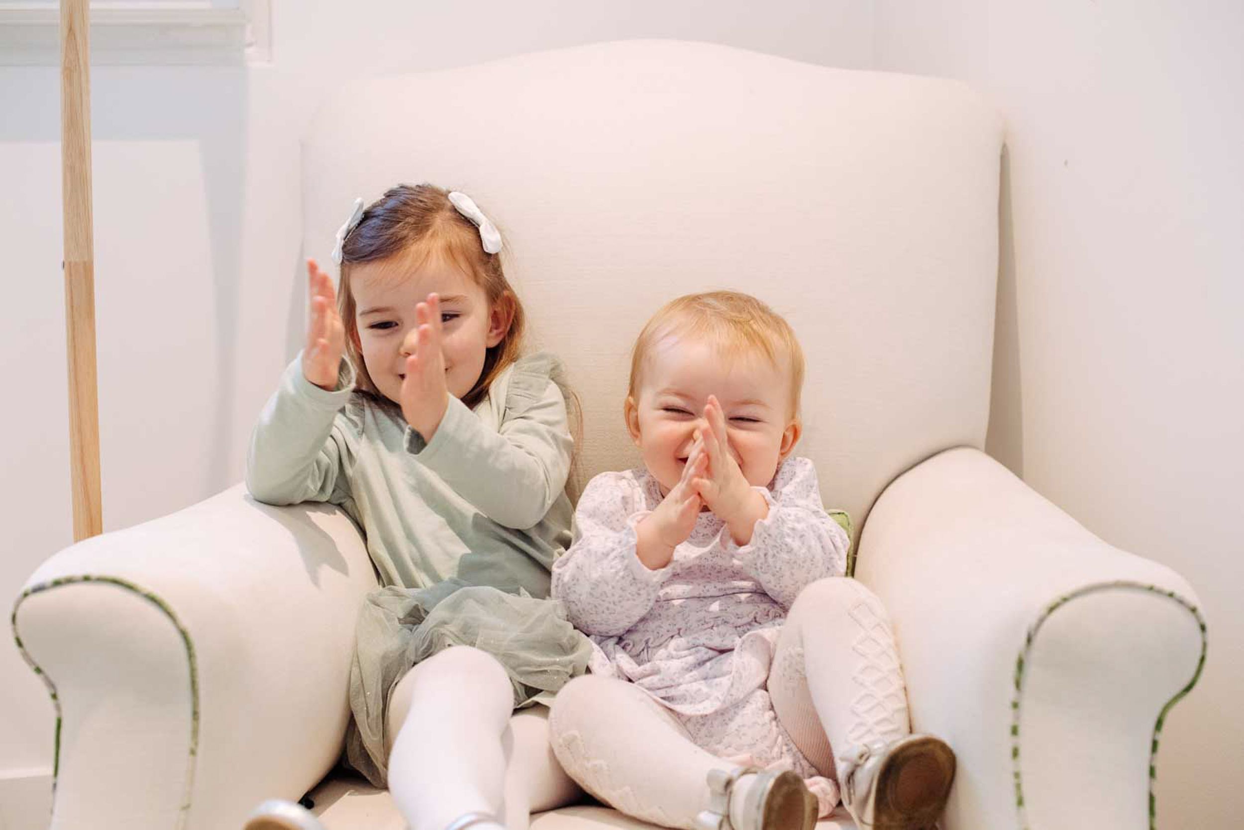 Sisters having fun during their London family photography session. Wearing mint dresses.