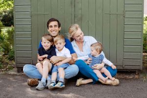 Family photography session in a park on a summer day. Family is dressed in jeans and t-shirts that a colour coordinated.
