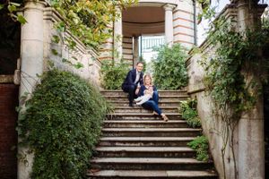 Family photography session in a park in Zurich during summer. Mum, dad and baby sitting on the steps in the park.