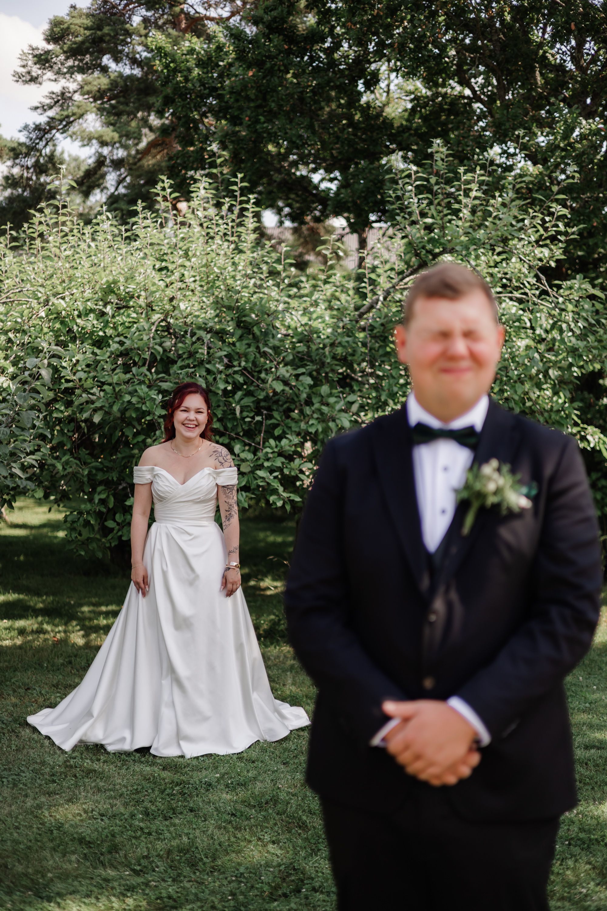 A wedding couple poses separately in an outdoor garden setting with lush greenery and natural lighting.