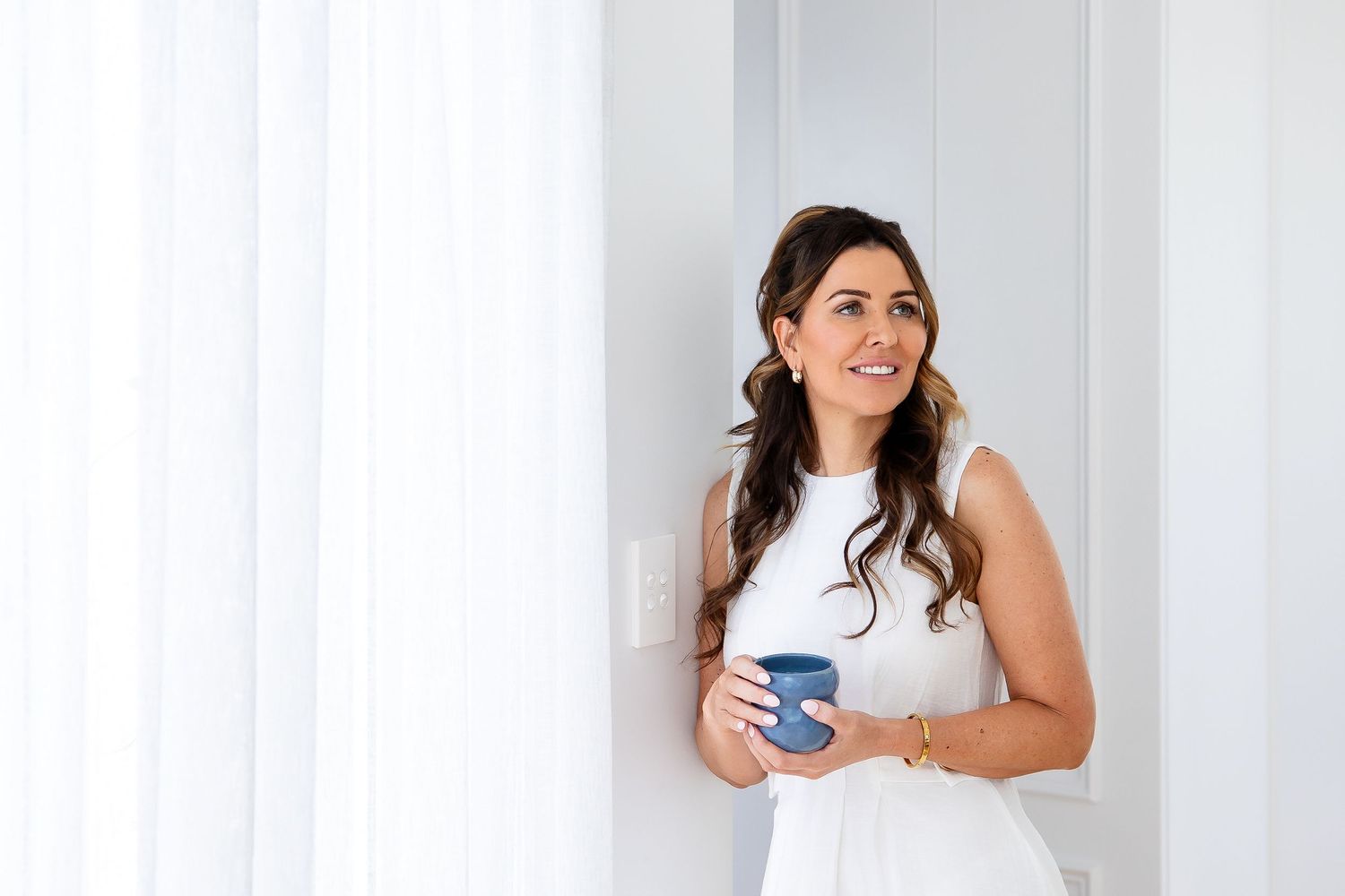 Professional lifestyle portraits of someone in white attire against a bright minimalist background.