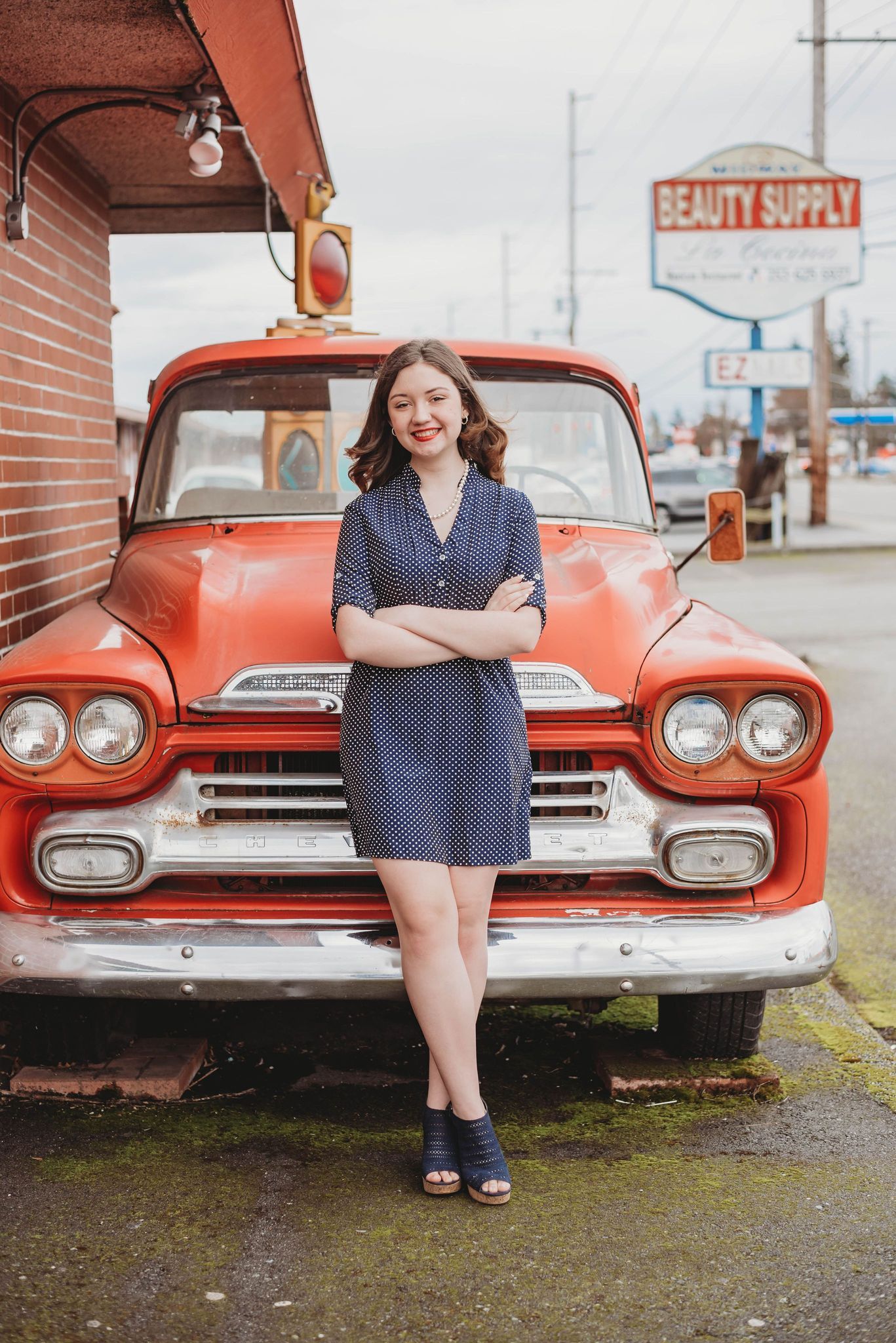 Classic red Chevrolet truck serves as backdrop for retro-styled photoshoot.