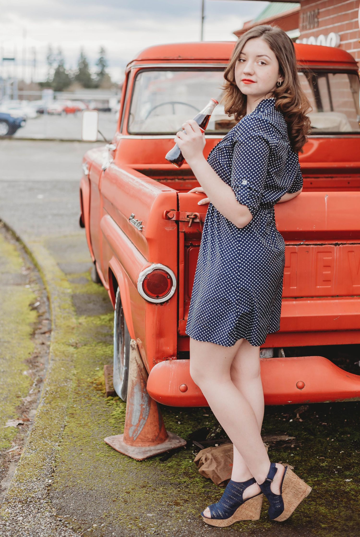 A series of fashion photos featuring a polka dot dress and red vintage pickup truck in an outdoor setting.