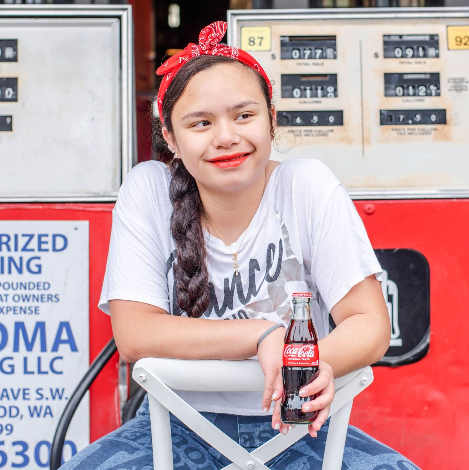 Retro gas station photoshoot featuring denim overalls and vintage signage.