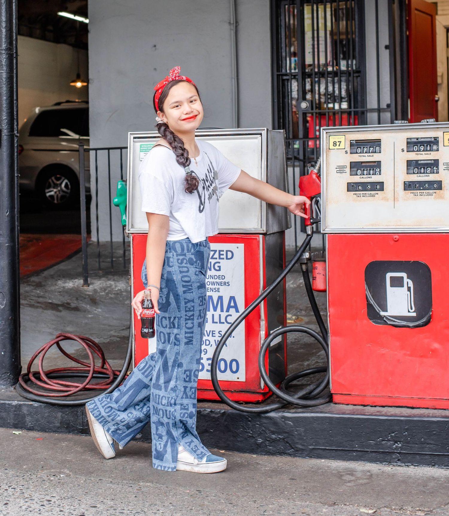 Candid poses at a vintage gas station with red and white color scheme.