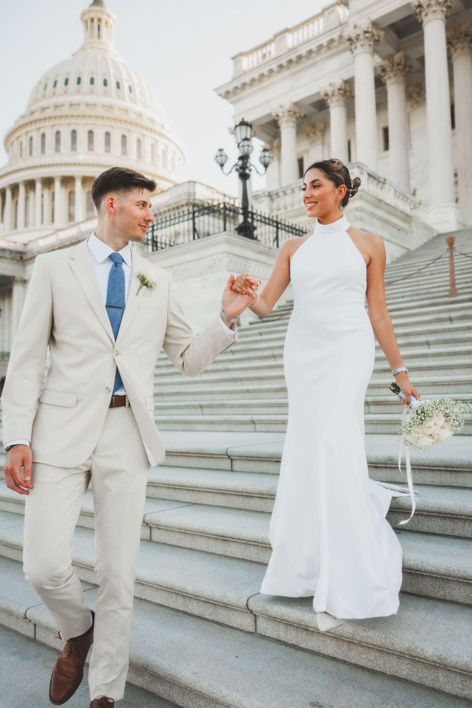 Elegant couple in formal attire on Capitol building steps.