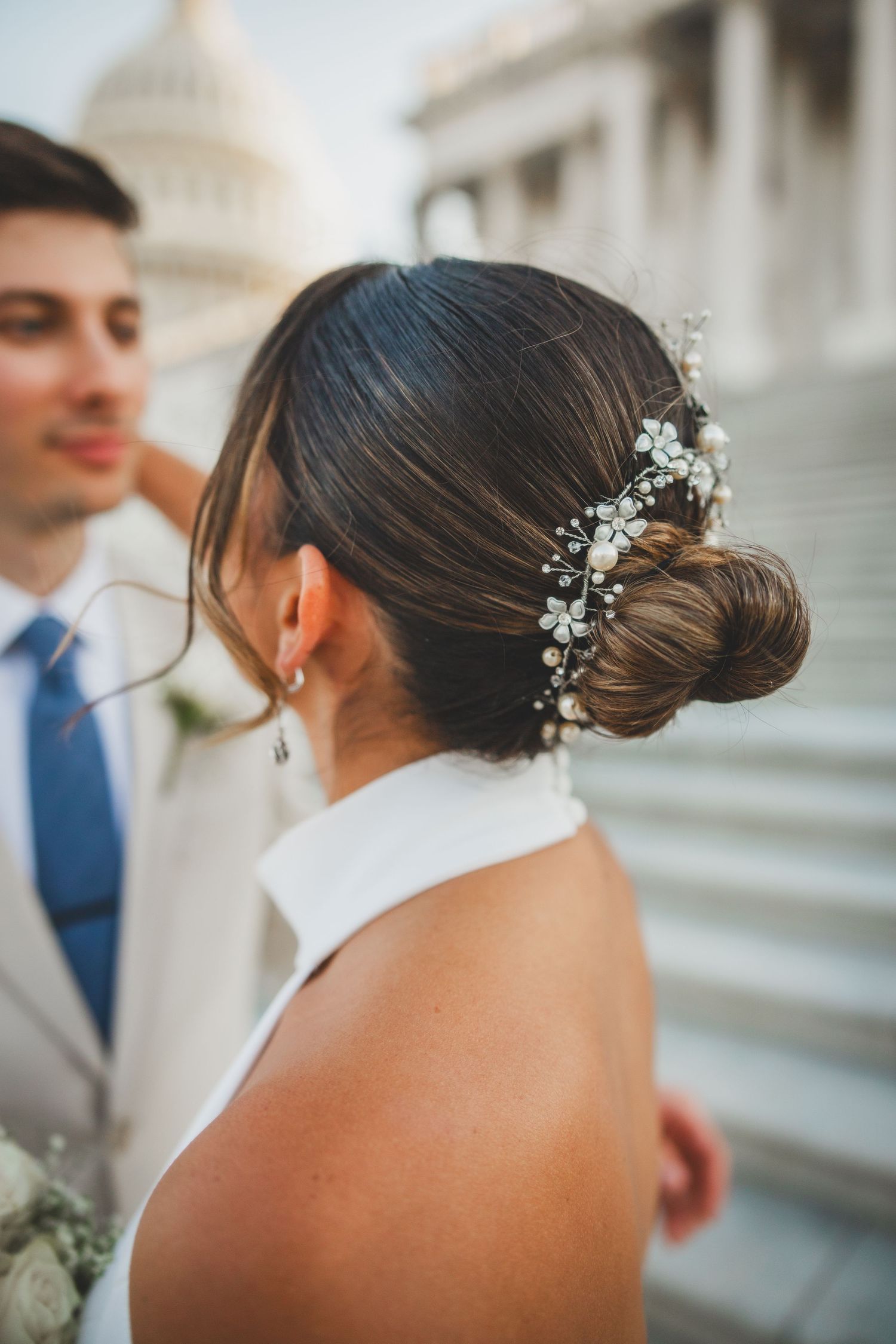 Elegant bridal hairstyle with crystal hair accessory against Capitol building backdrop.