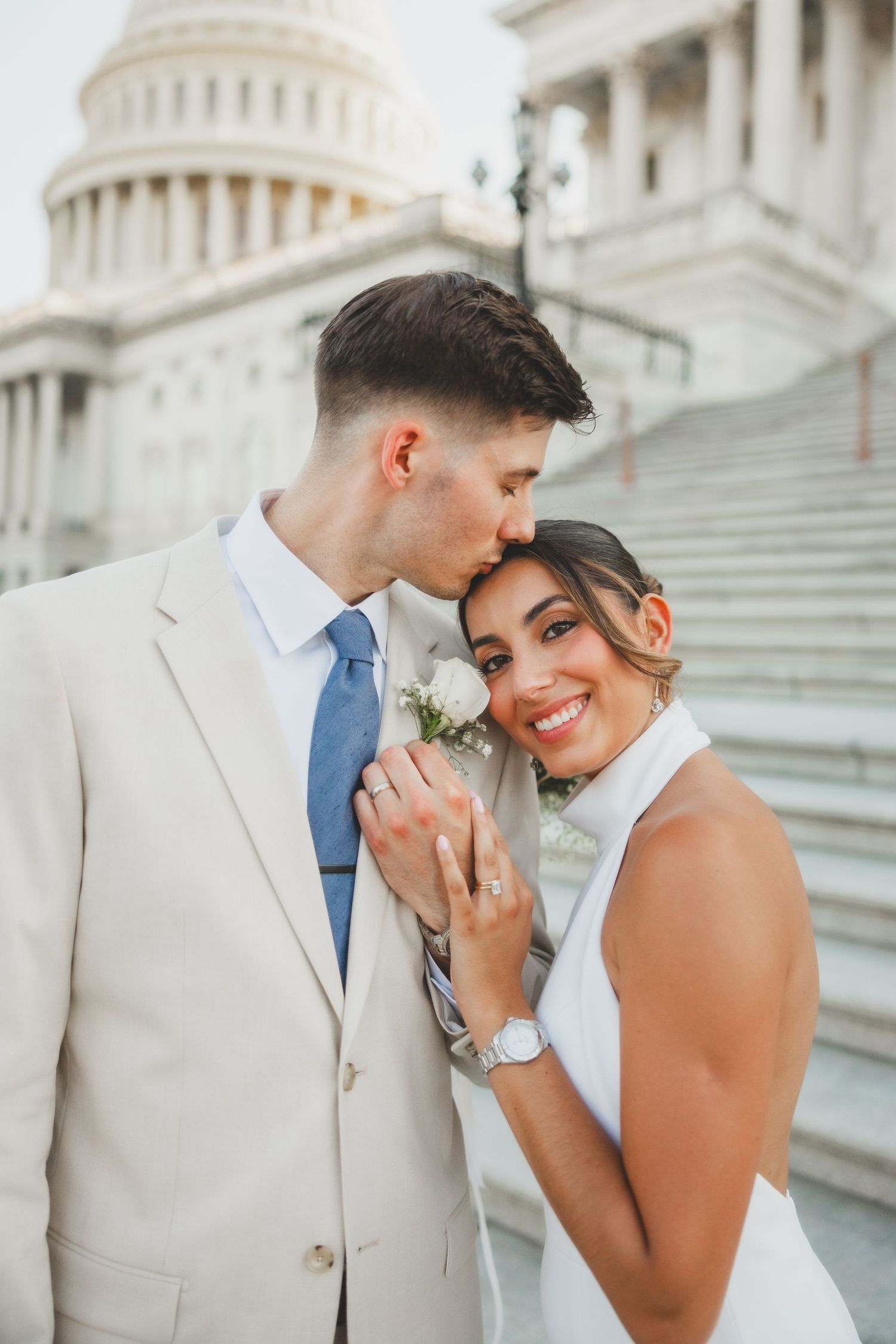 Wedding couple embracing on steps of US Capitol building.