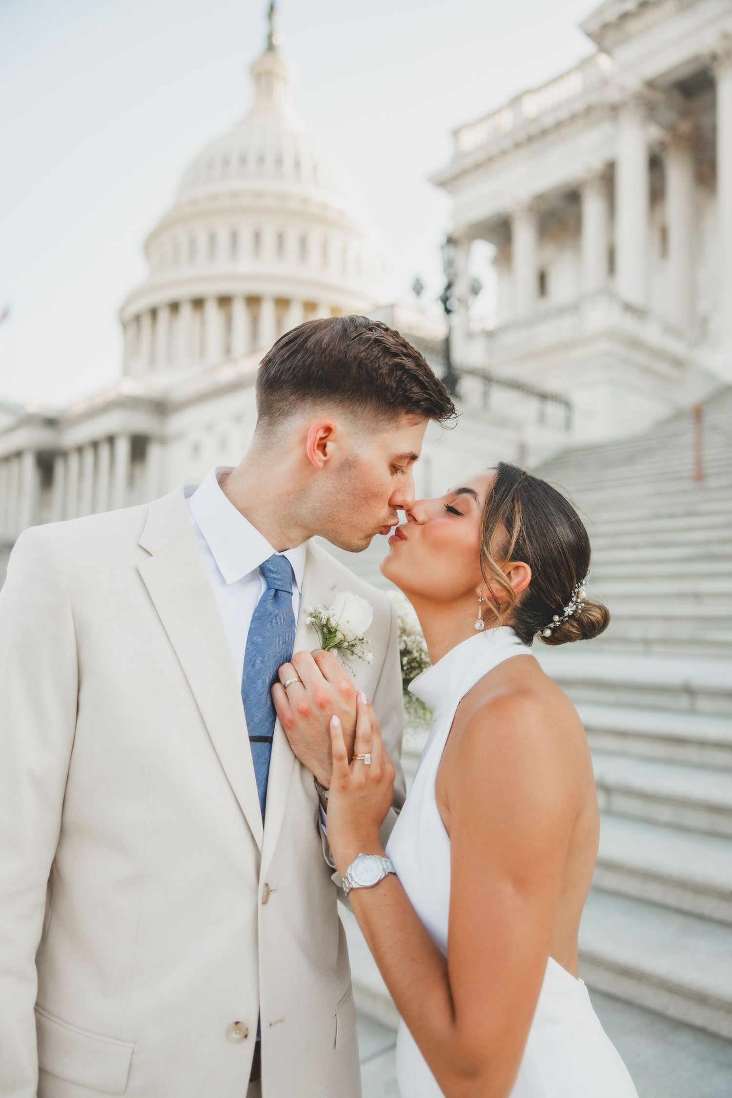 Romantic wedding moment captured on steps of US Capitol building.