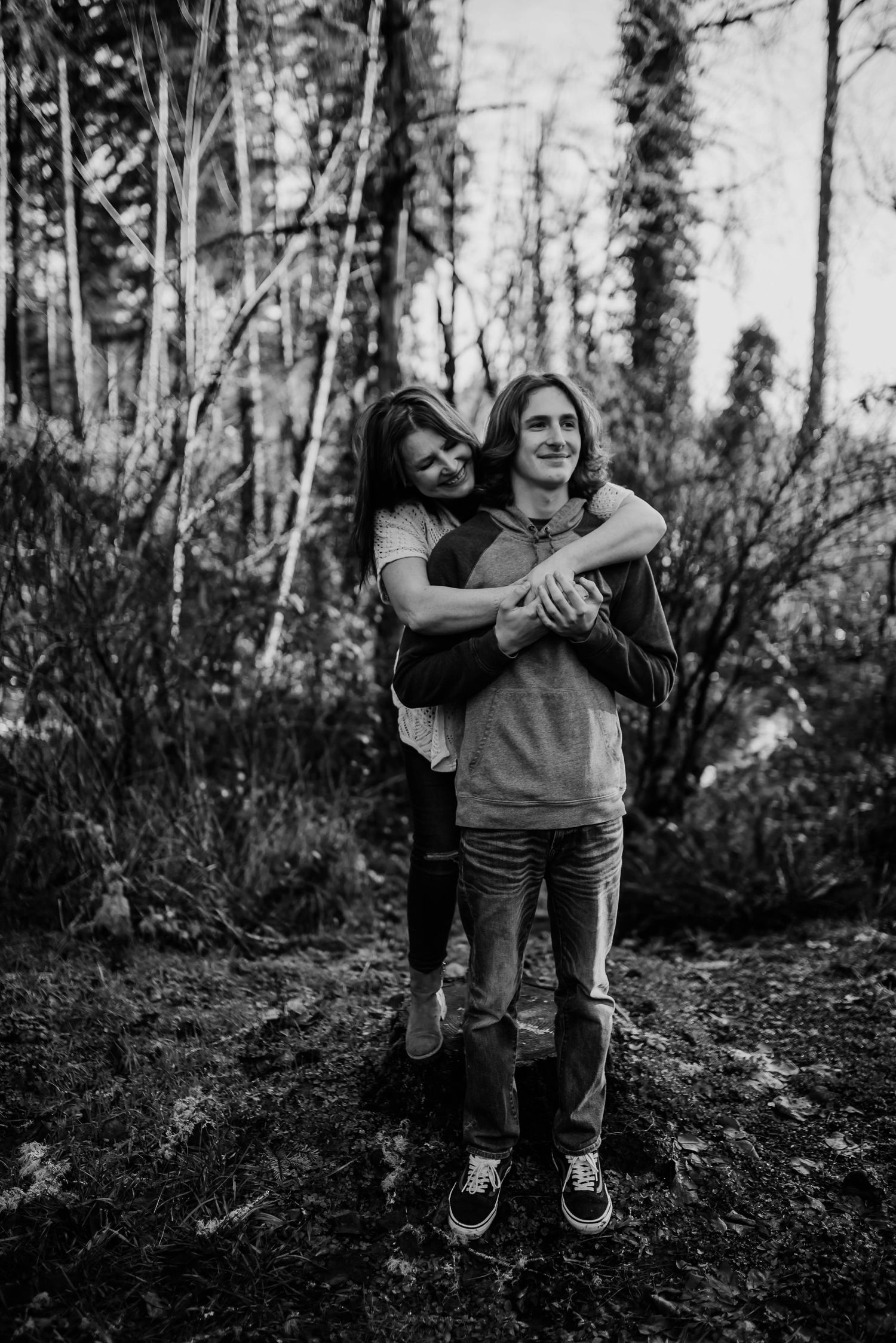Black and white candid shot of playful moment in wooded setting.