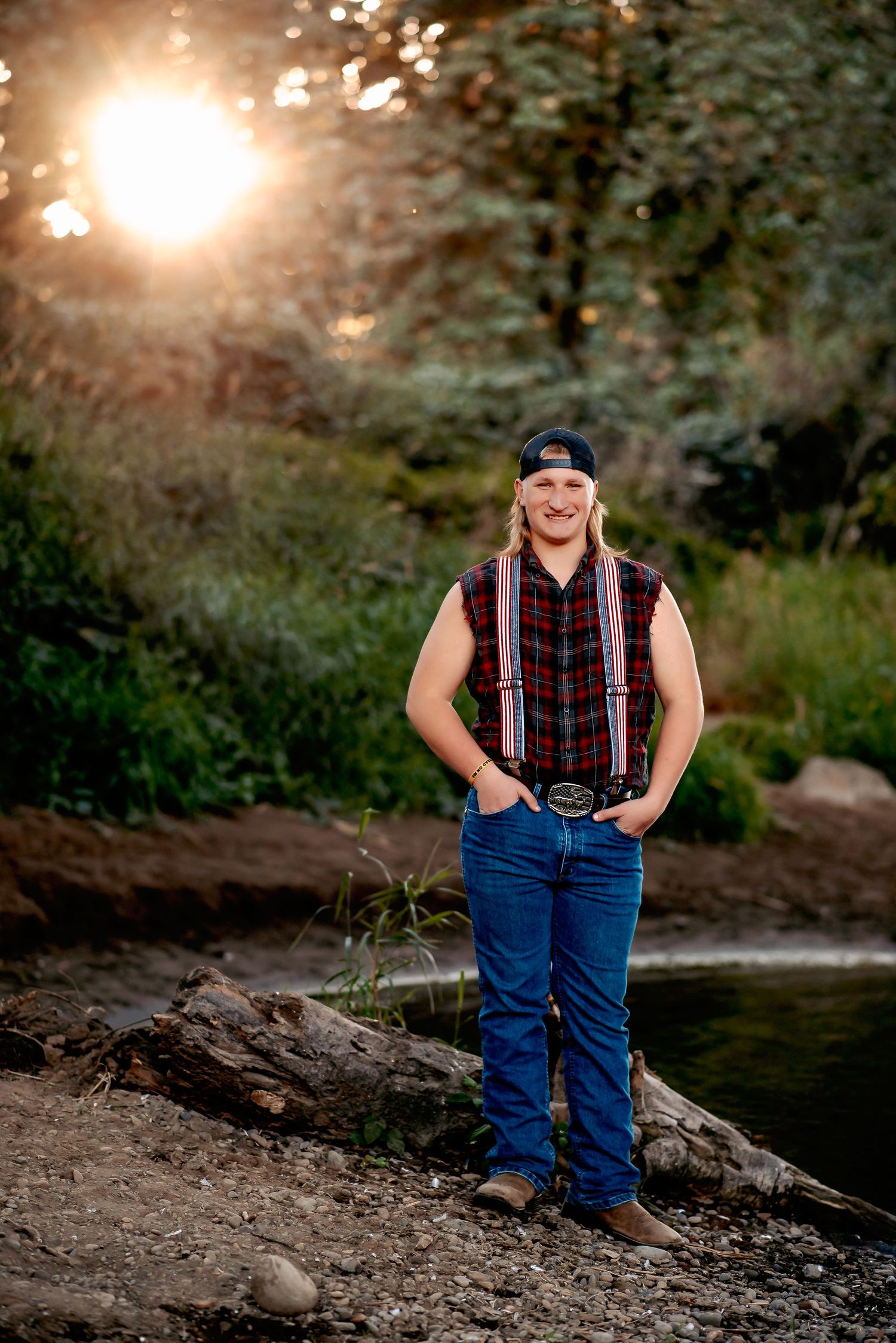 A rustic outdoor photoshoot featuring casual denim and plaid attire against a sunlit wooded backdrop.