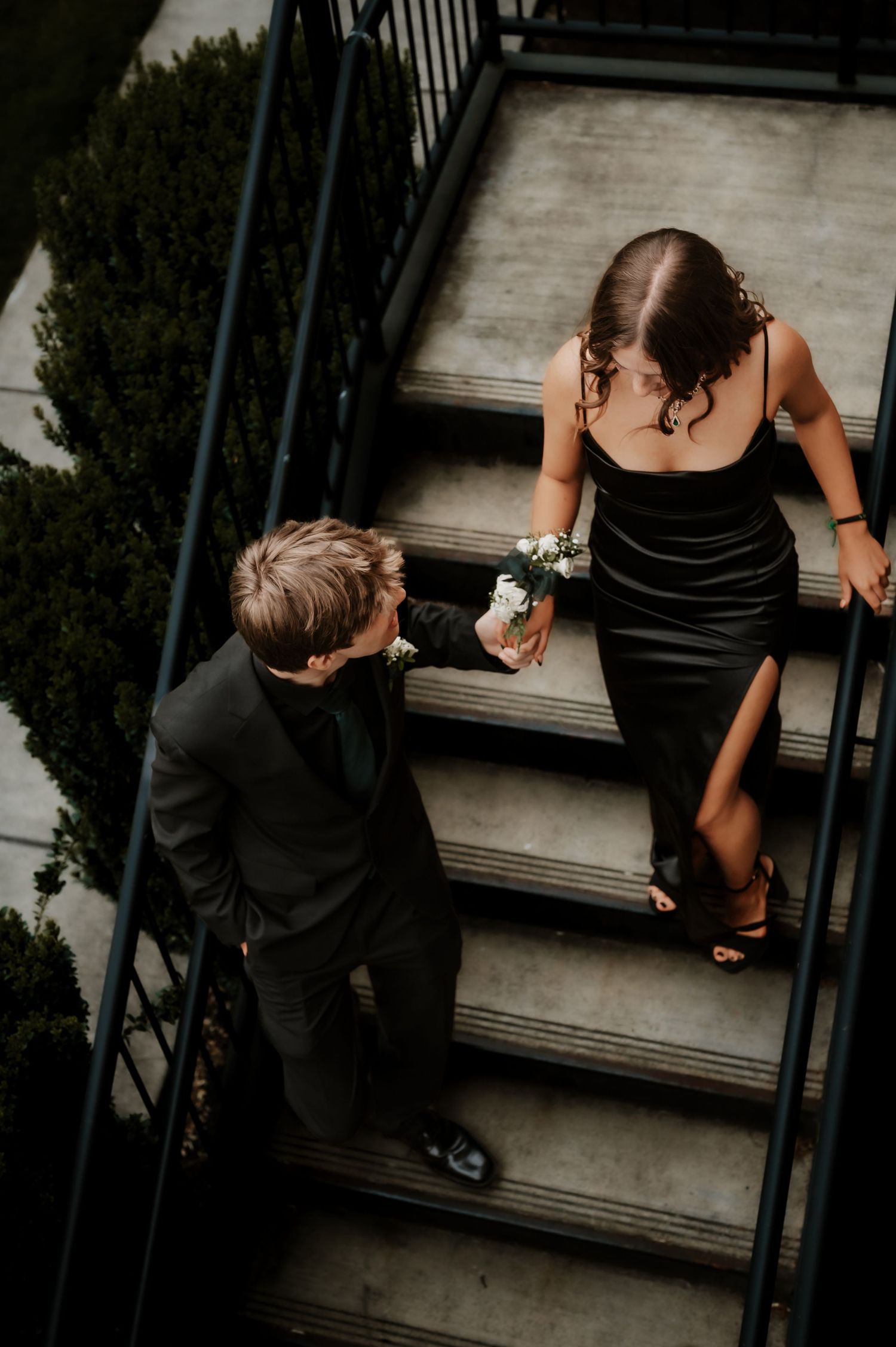 Romantic couple shares intimate moments on outdoor stairs during sunset.