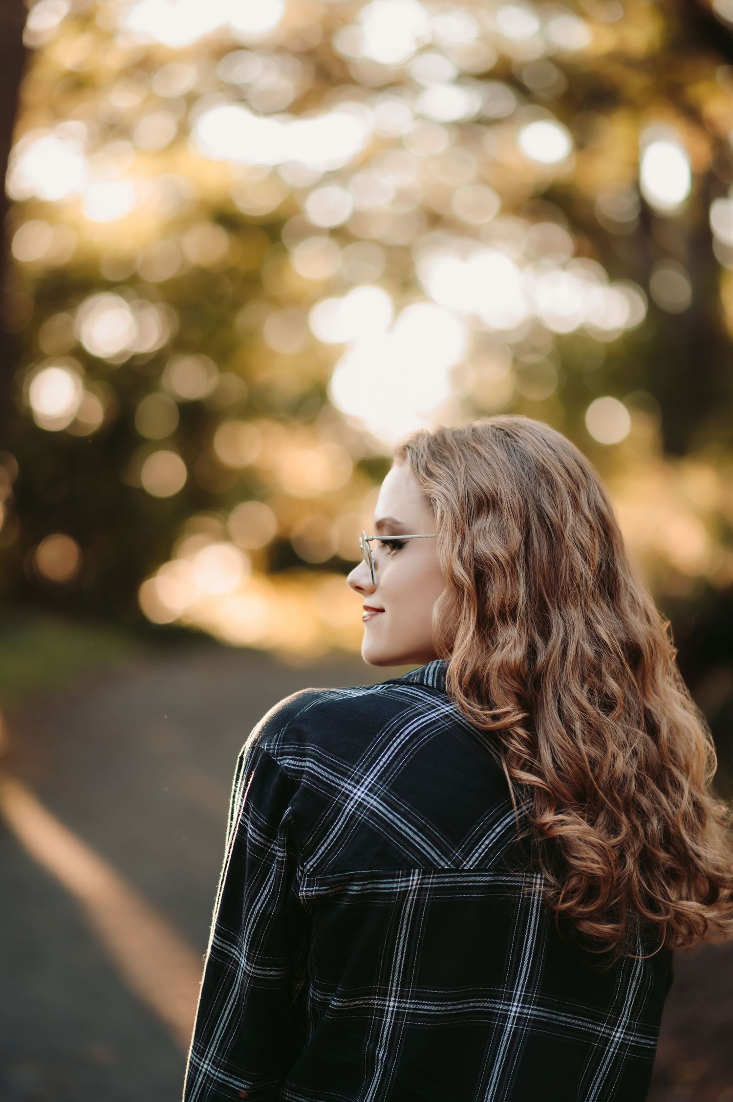 Side profile portrait with plaid jacket in warm evening sunlight.