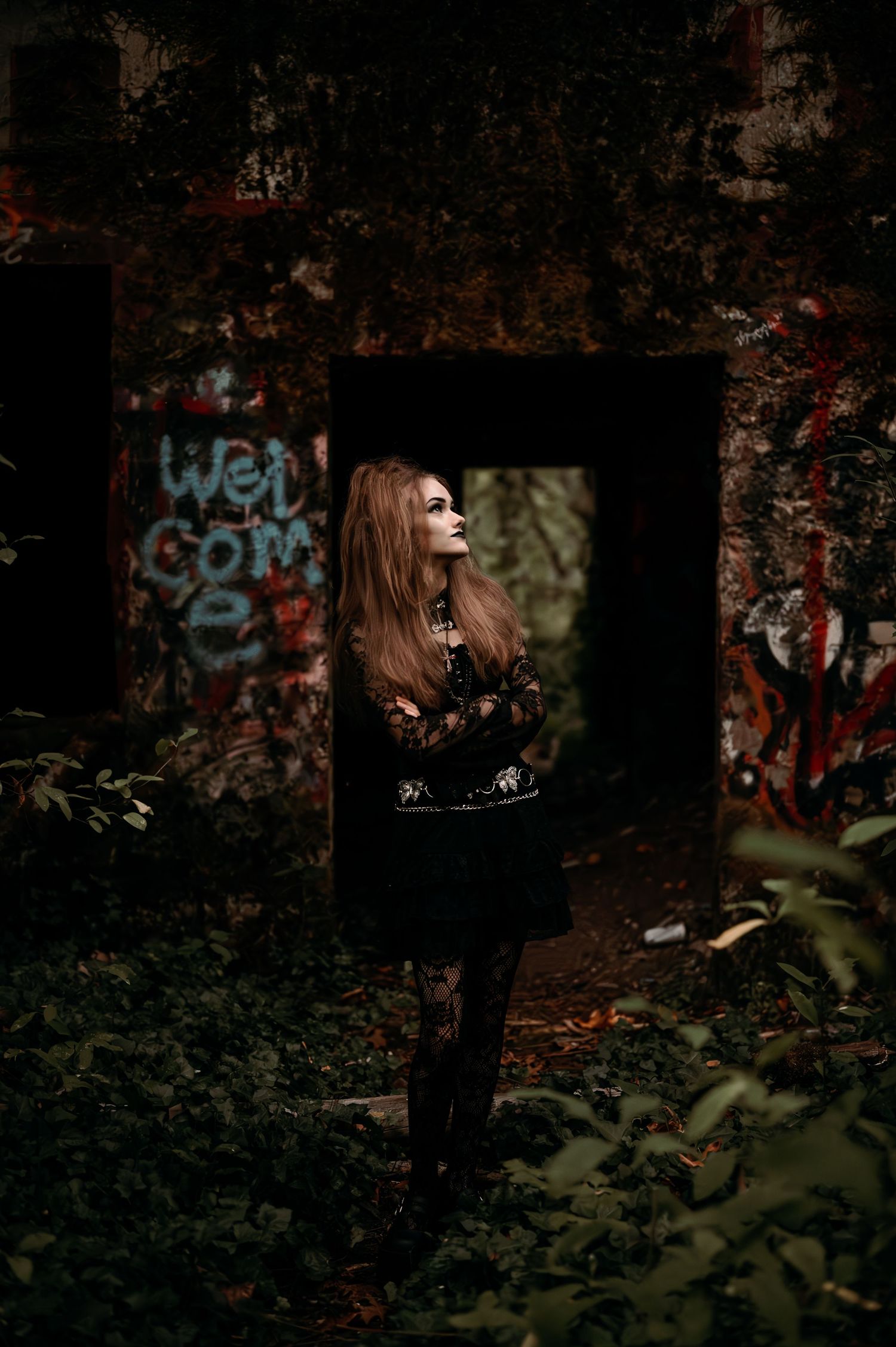 Dark moody outdoor photoshoot with graffiti wall backdrop.