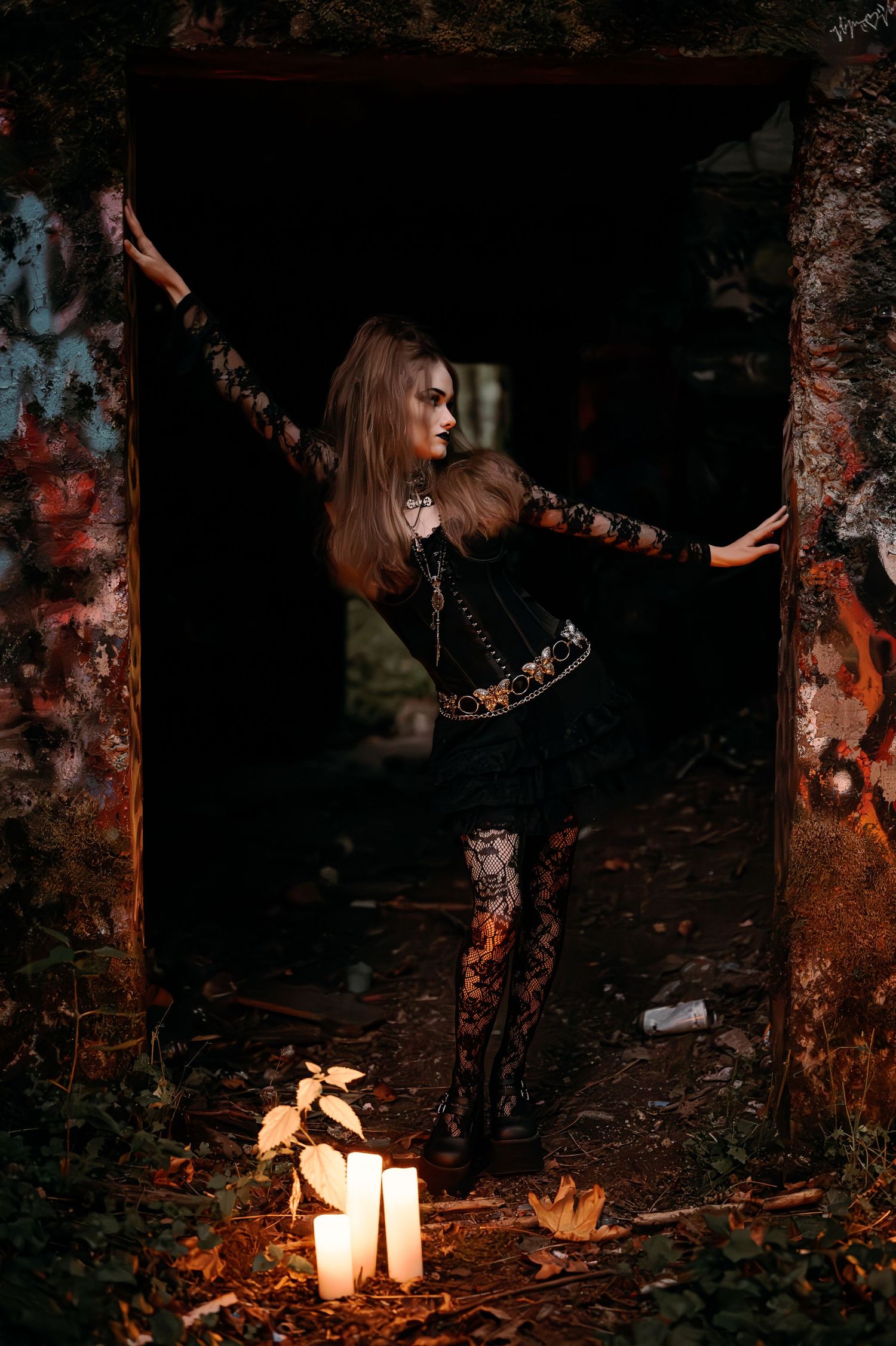 Atmospheric night scene with candles and figure in dark lace among trees.