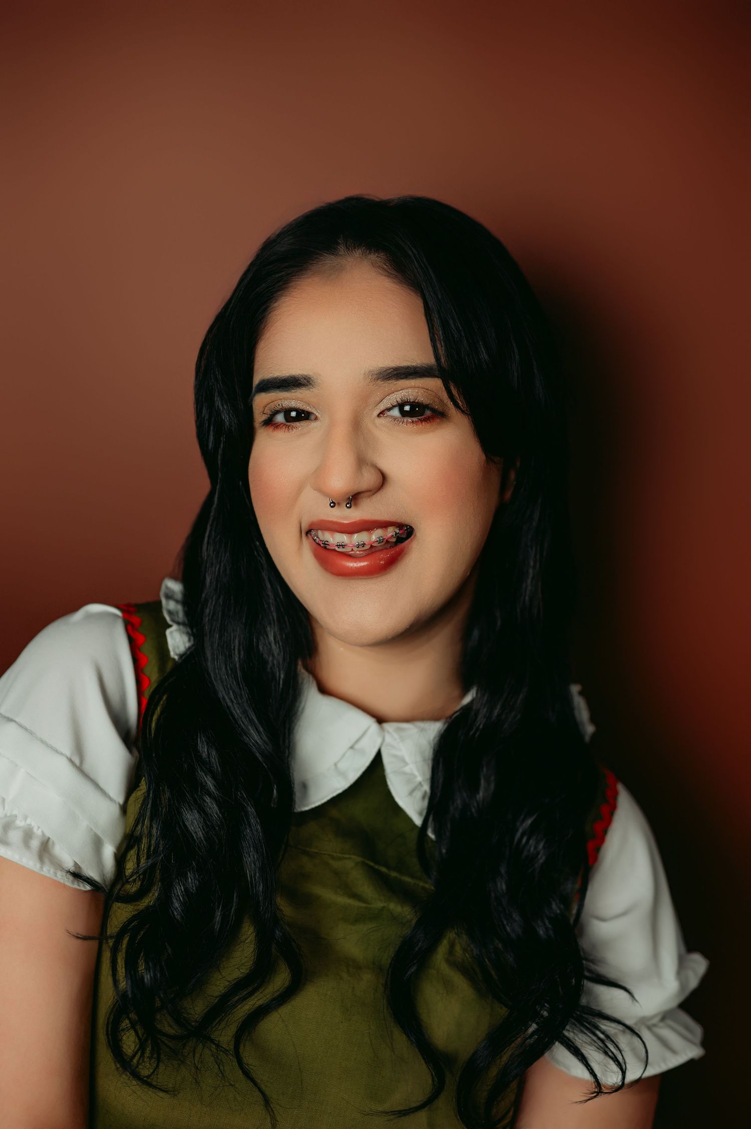 Close-up studio portrait showing bright red lipstick and white collar.