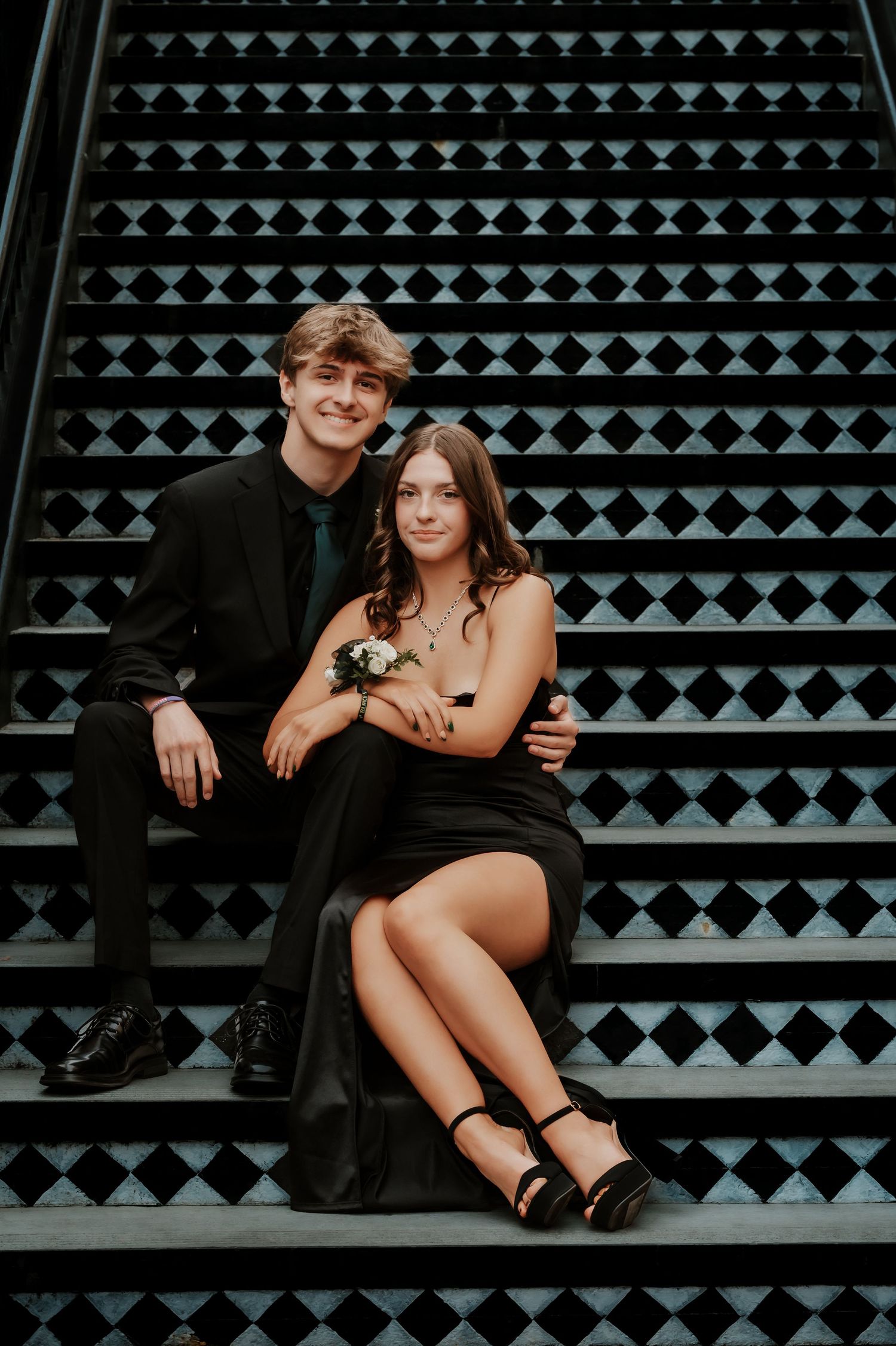 Couple sits intimately on geometric patterned stairs during a photo session.