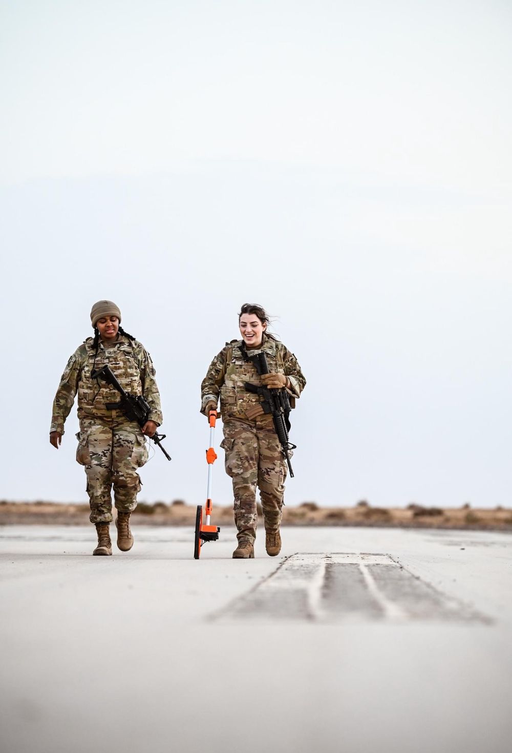 Military personnel running on airfield tarmac during training exercise.