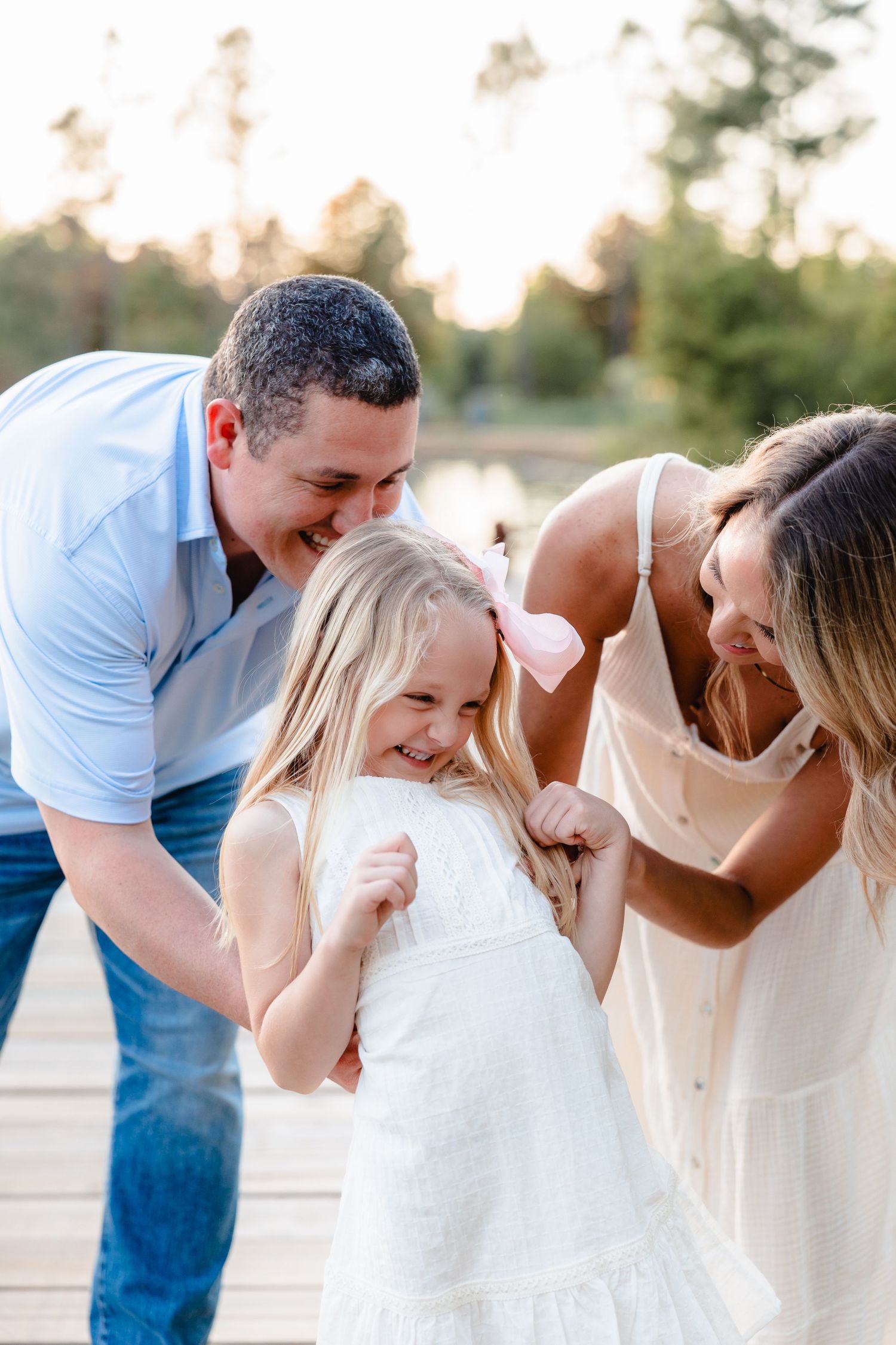 Family sharing a joyful moment together on a dock during golden hour.