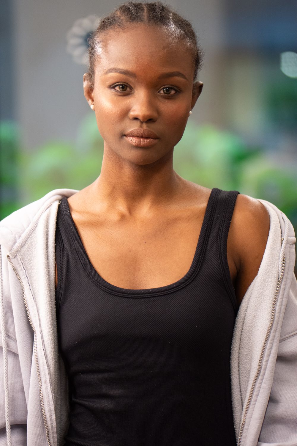 A headshot of a fashion model in a black t-shirt and hoodie, London, UK
