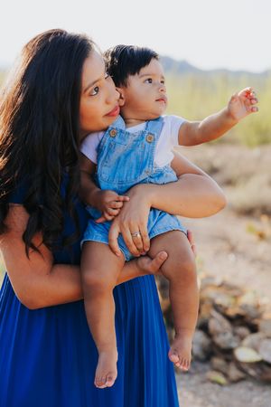 Intimate family portrait with desert mountains and cacti in the background.