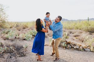 Family playing and laughing together in a scenic desert environment.