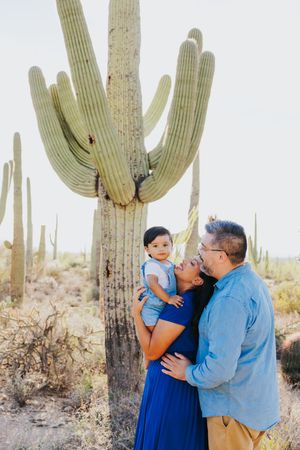 Family portrait beneath a majestic saguaro cactus in the desert.