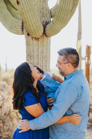 Candid family moment captured under a towering saguaro cactus.