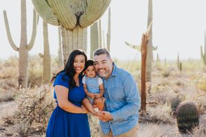 Sweet family moment captured in the Sonoran desert surrounded by tall saguaro cacti.
