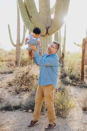 Playful family interactions photographed among giant saguaro cacti in the desert.