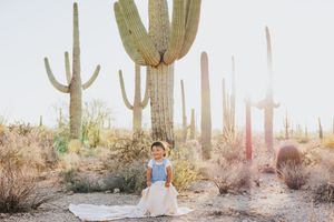 Desert photoshoot featuring natural light and dramatic saguaro cacti in the background.
