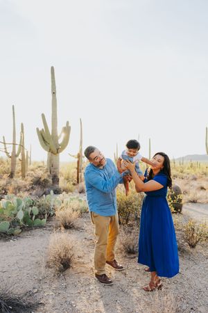 A couple dances playfully in the desert surrounded by majestic saguaro cacti.