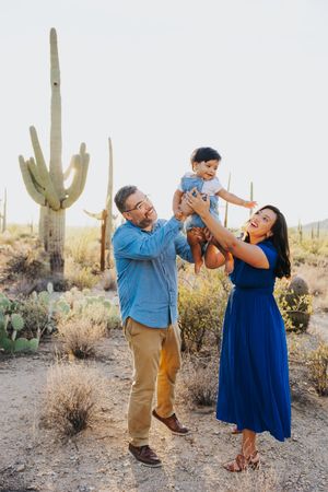 A couple shares a romantic dance moment among desert cacti during a photo session.