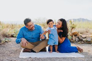 Candid family moment captured during desert photoshoot with mountains in background.