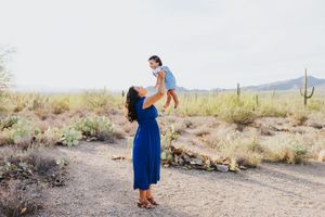 A heartwarming family moment captured in a desert setting with saguaro cacti.