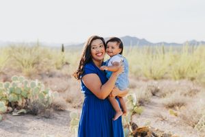 Mother and child sharing a tender moment against a desert landscape backdrop.