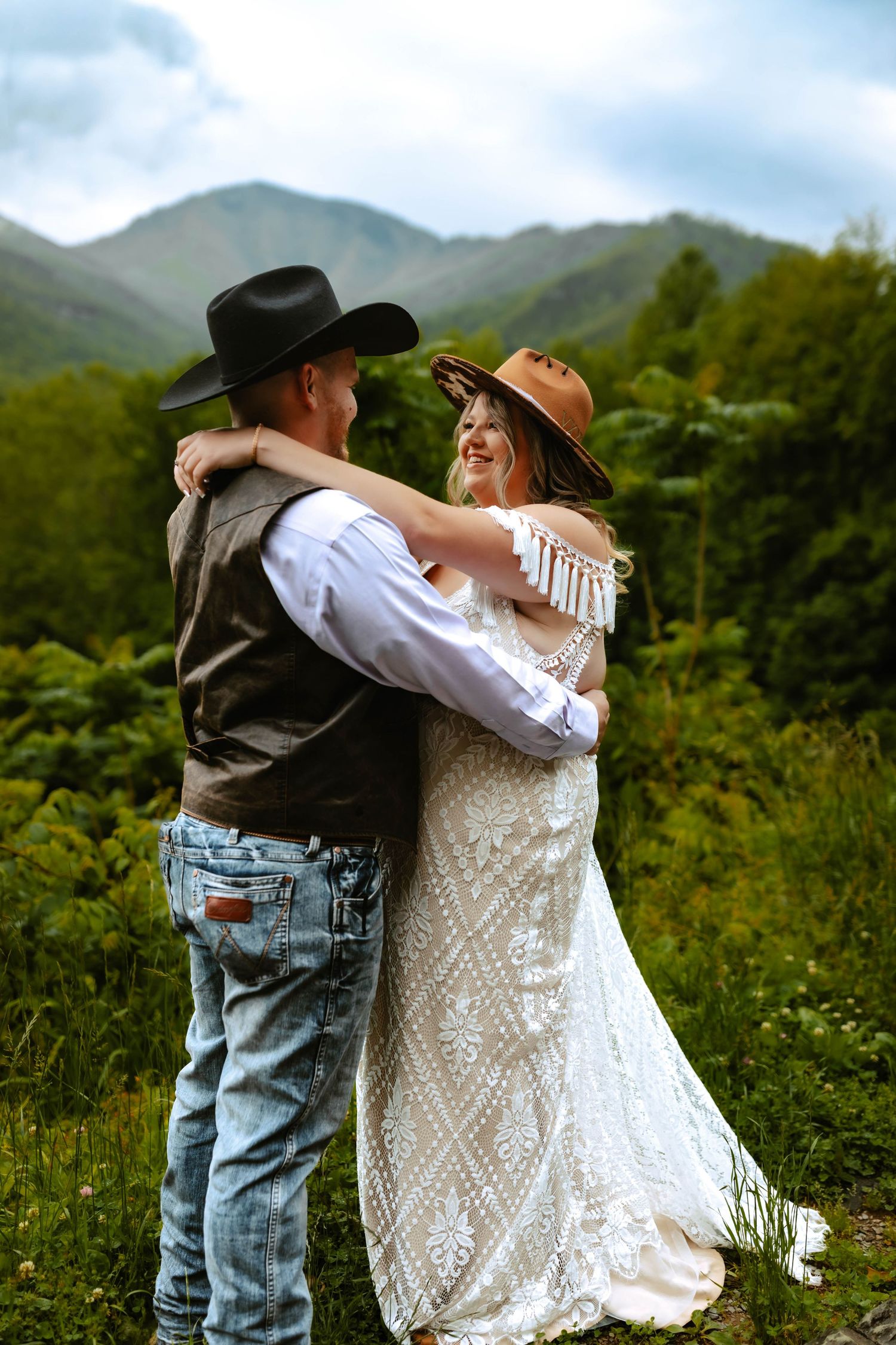 A newlywed couple shares a romantic moment on a wooden dock overlooking a serene autumn pond in the countryside.