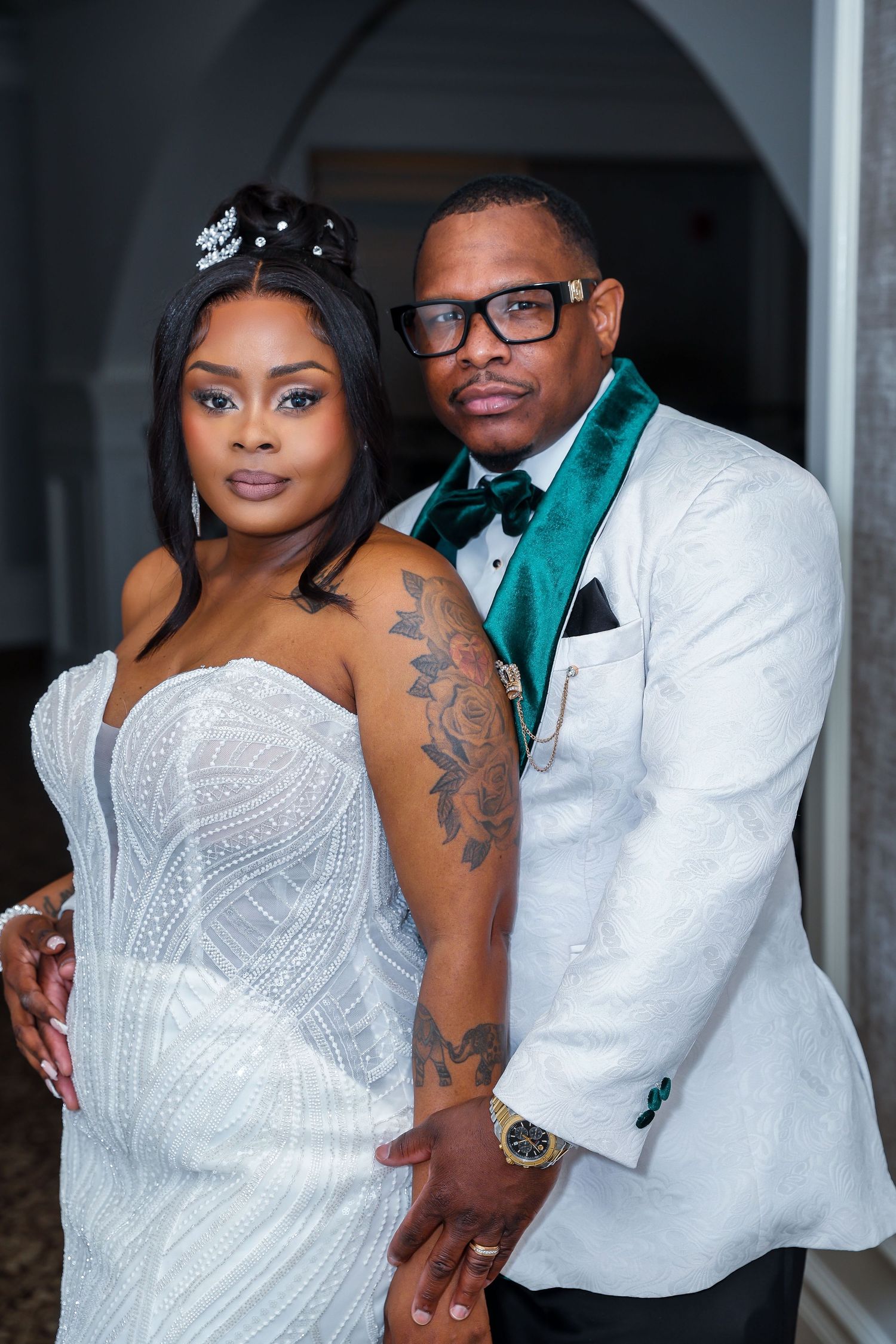 Formal wedding portrait featuring couple in white and emerald green attire.