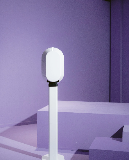 Sleek white cylindrical light installation against purple wall in contemporary space.