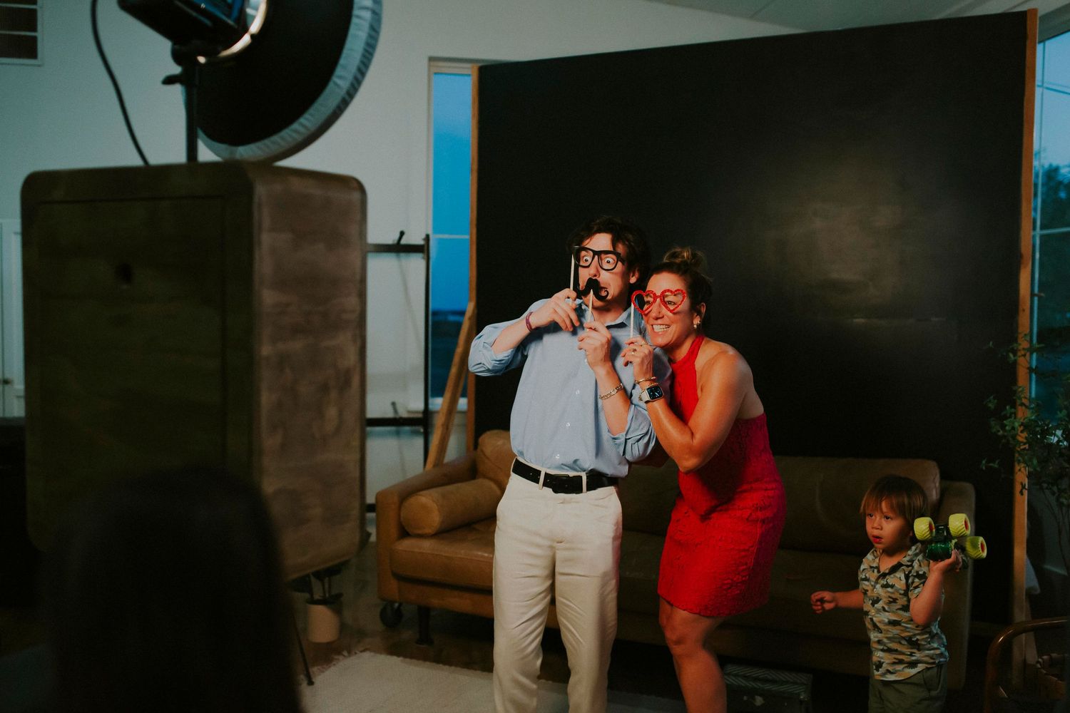 Dynamic photo session with red dress accent against modern studio backdrop.